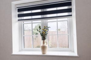 a window with a vase with flowers in it at Spacious En-suite Private Double Bedroom in Oxford