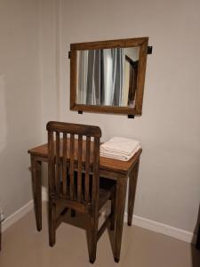 a wooden table with a mirror and a wooden chair at Waceno Umma in Ruteng +6 photos