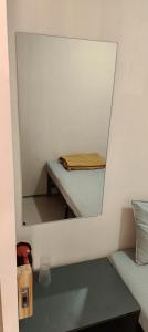 a mirror in a room with a table and a bed at Ekanaa Cottages in Chennai