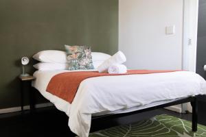 a bedroom with a bed with white sheets and pillows at Foools Inn - Trendy Rooms available in the Heart of Sea Point! in Cape Town