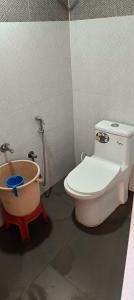 a bathroom with a toilet and a bath tub at Ekanaa Cottages in Chennai