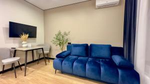 a blue couch in a living room with a table at MOLODIST 16 Irpin in Irpin