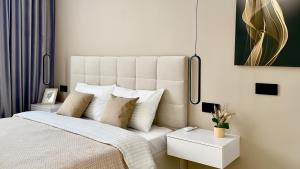 a bedroom with a large white bed with pillows at MOLODIST 16 Irpin in Irpin