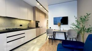 a kitchen with white cabinets and a table and chairs at MOLODIST 16 Irpin in Irpin