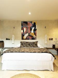 a bedroom with a large bed with a painting on the wall at Bastide Nomade - guest house in Saint Paul de Vence