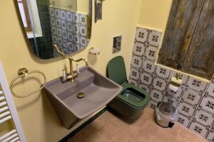 a bathroom with a sink and a green toilet at Spiritu in Ḩārat al Qal‘ah