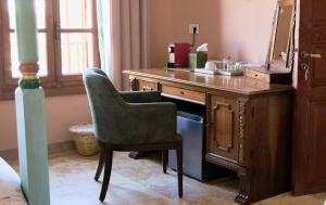 a desk with a chair and a sink in a room at Spiritu in Ḩārat al Qal‘ah