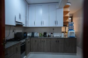 a kitchen with white cabinets and a counter top at Kaze Consolidate Home Inn in Kigali