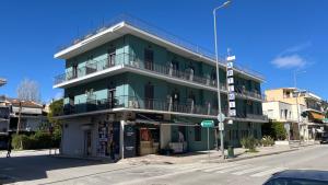 a green building on the corner of a street at Artemis in Nafplio