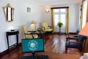 The Golf Green City Bungalow في نوارا إليا: غرفة معيشة مع جهاز كمبيوتر على طاولة