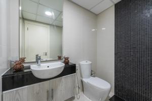 a bathroom with a sink and a toilet and a mirror at Urban Chic - Marina Bay in Abu Dhabi