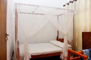 a bed with a canopy in a room at Ivy Cottage- Midigama in Midigama East