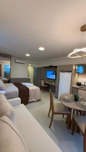 a bedroom with a bed and a living room at Flat Luxo em Boa Viagem - 5min do Aeroporto - perto da praia - Wi-Fi 500mb - check-in 24h in Recife
