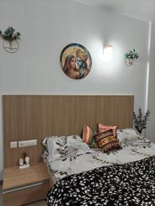 a bedroom with a bed with a picture on the wall at Shivaya Homes in Chhatikara