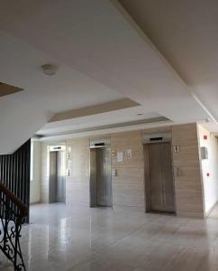 a hallway with many elevators in a building at Shivaya Homes in Chhatikara