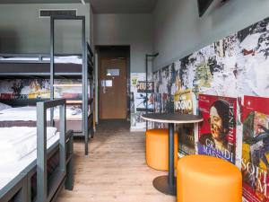 a room with bunk beds and a table in it at a&o Hostel Milano Ca Granda in Milan