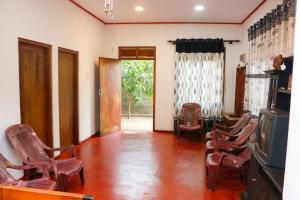 a living room with rocking chairs and a television at Ivy Cottage- Midigama in Midigama East
