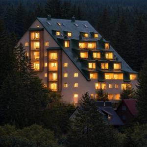 a large building with its lights on at night at Apartments & rooms Concept Nordica in Žabljak