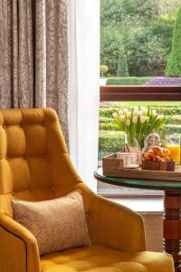 a yellow chair sitting next to a table with a window at St Helens Hotel, Dublin in Stillorgan