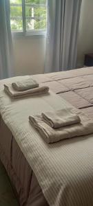 two towels are sitting on top of a bed at Duplex Atenea in Chivilcoy