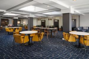 a lobby with tables and chairs and a couch at Courtyard Hartford Cromwell in Cromwell