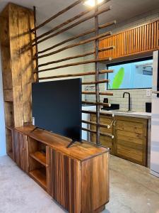 a flat screen tv on a wooden stand in a room at Bangalôs Riviera do Patacho in Pôrto de Pedras