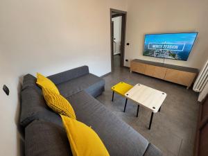 a living room with a couch and a tv at La Gare Apartments - Zerbion in Châtillon