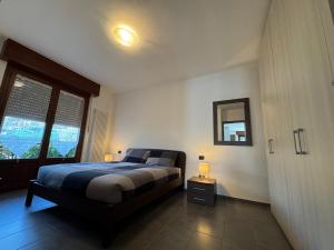 a bedroom with a bed and a large window at La Gare Apartments - Zerbion in Châtillon