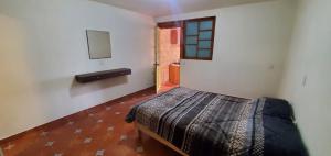 a bedroom with a bed and a small window at Zirahuén 6 personas in Zirahuén