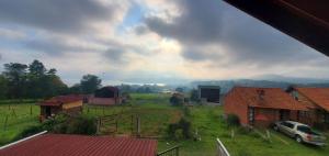 a view of a farm with a car parked in a field at Zirahuén 6 personas in Zirahuén