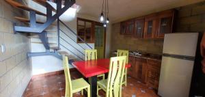 a kitchen with a red table and yellow chairs at Zirahuén 6 personas in Zirahuén