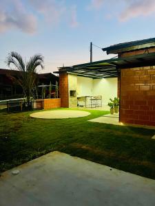 a brick house with a patio and a yard at Refúgio no Campo in Mairinque