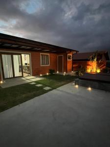 a house with lights in the yard at night at Refúgio no Campo in Mairinque