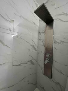 a bathroom with white marble walls and a shower stall at Studio Apartment with backyard - All Private! in Homestead
