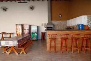 a kitchen with a table and chairs and a counter at Suítes privativas, camas confortáveis, piscina, churrasqueira e playground, Roupa de Cama e tolha de banho. in Rubinéia