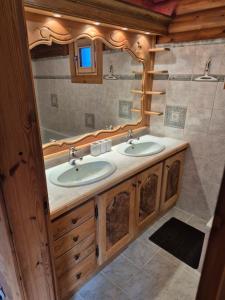 a bathroom with two sinks and a mirror at le chalet in Planay