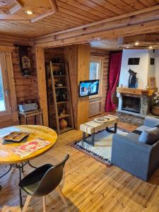 a living room with a table and a fireplace at le chalet in Planay