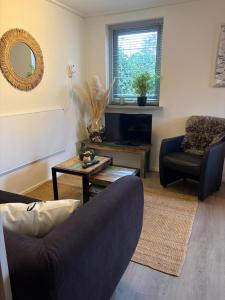 a living room with a couch and a chair at Waves in De Koog