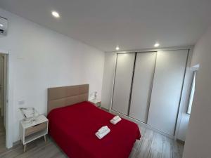 a bedroom with a red bed with two towels on it at CASA ANALUCIA in Faro