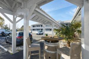 a white pergola with a table in a parking lot at Kyriad Bordeaux - Merignac Aéroport in Mérignac