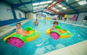 two children riding in an indoor swimming pool at Shells at Sandylands in Stevenston