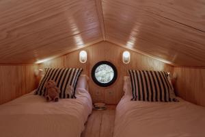 a small room with two beds and a teddy bear at HolaCamp la Franca in Las Conchas