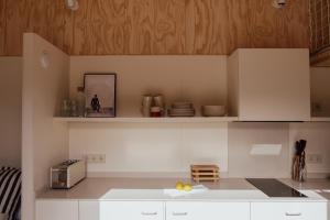 a kitchen with white counters and wooden cabinets at HolaCamp la Franca in Las Conchas +12 photos
