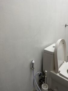 a bathroom with a white toilet with a hose at Bahari guesthouse in Nungwi
