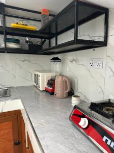 a kitchen with a counter top with a stove top oven at Bahari guesthouse in Nungwi +2 photos