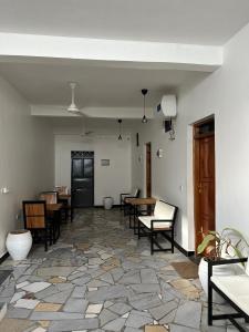 a room with tables and chairs in a room with a stone floor at Bahari guesthouse in Nungwi