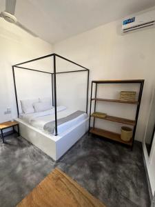 a bedroom with a bed with a metal canopy at Bahari guesthouse in Nungwi