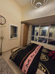 a bedroom with a bed and a clock on the wall at Apartment in ajman in Ajman 