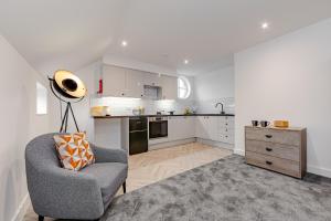 a living room with a chair and a kitchen at Studio Room, Parking, Contractors and Relocators, Weekly Deals in Maidstone