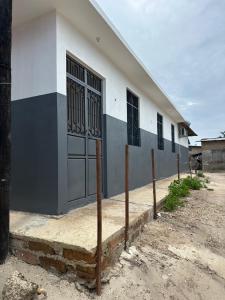 a building with a fence in front of it at Bahari guesthouse in Nungwi